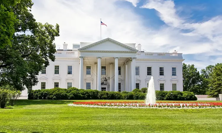 The White House on a summer day with the American flying over it.