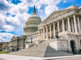 Bright mid-day view of the traditional neoclassical architecture of the Capitol Building’s dome, columns, and steps in Washington DC, USA